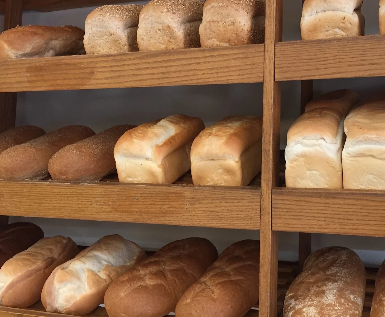 Loaves of fresh bread on wooden shelves at Grandin Bakery